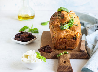 Savoury loaf cake with dried tomatoes, mozzarella and basil. Selective focus.