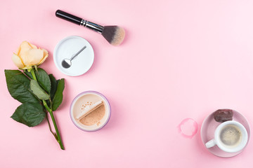 Obraz na płótnie Canvas Beige face powder and brush for make up, rose, cup of coffee on pink background with copy space, flat lay