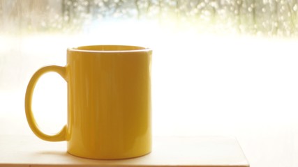 Yellow cup on wooden background