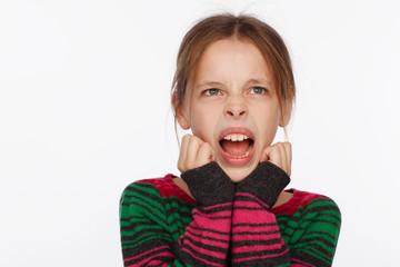 Portrait of a screaming 8-year-old girl in a sweater in crimson and green stripes