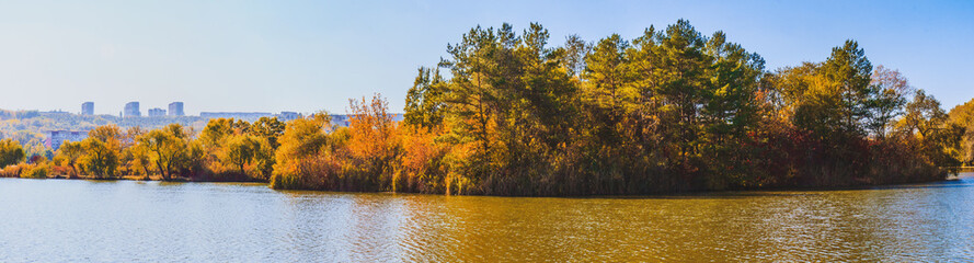 Autumn panorama forest and lake in a sunny day