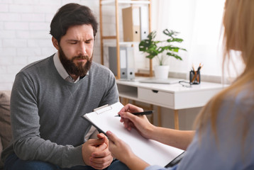 Stressed man talking to psychologist, solving his personal problems