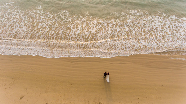 Happy wedding couple posing on beach