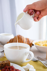 Mug of coffee on the table with English breakfast and croissant