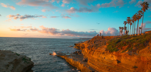 miniature people watching the sunset from the cliffs in San Diego