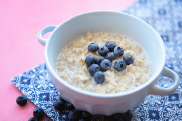 Oatmeal porridge with blueberry, blackberries and currants for breakfast