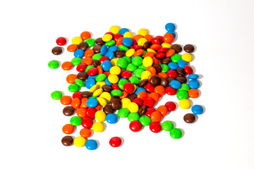 Colorful chocolate MMs in and out of focus on white background