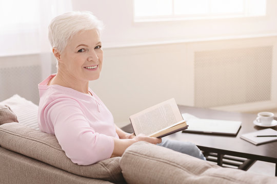Elegant senior lady relaxing with favorite book