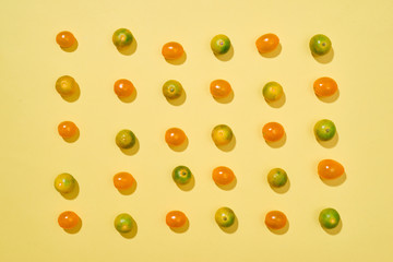 Seamless pattern with tomatoes and Calamondin or citrus microcarpa. Abstract background. Tomato on the yellow background