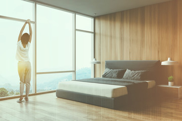 Woman in wooden panoramic bedroom corner