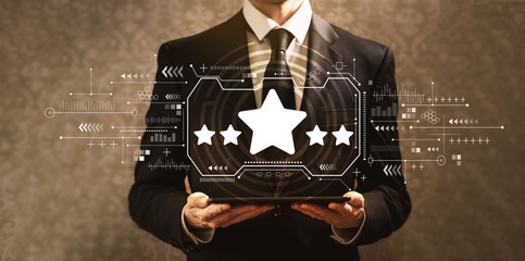 Five star rating with businessman holding a tablet computer