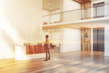 Fototapeta premium Man in office lobby with elevator and reception