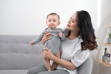 happy loving family. mother playing with her baby in the living room.