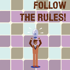 Conceptual hand writing showing Follow The Rules. Concept meaning go with regulations governing conduct or procedure Businessman Raising Arms Upward with Lighted Bulb icon above