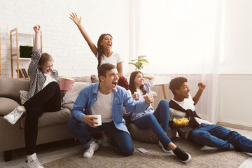Friends cheering for favourite football team, watching match