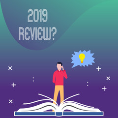 Writing note showing 2019 Review Question. Business concept for remembering past year events main actions or good shows Man Standing Behind Open Book Jagged Speech Bubble with Bulb