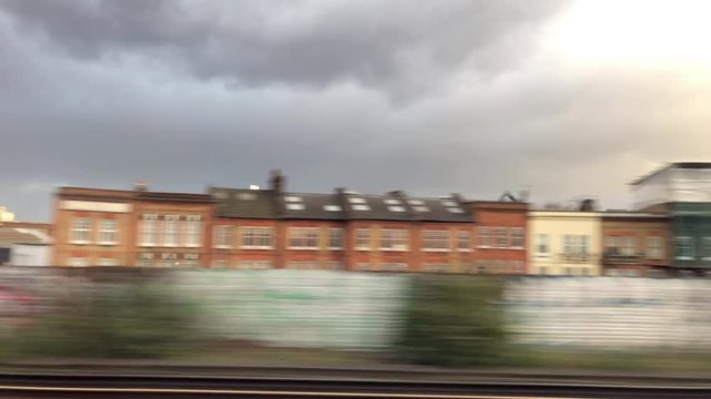 First person view from a window of a train carriage hurtling through an urban landscape and in particular an industrial estate. London.