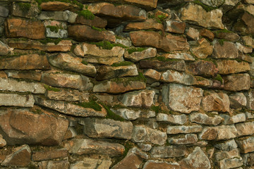 The texture of the wall of cobblestones. stone walls historic site. moss plant