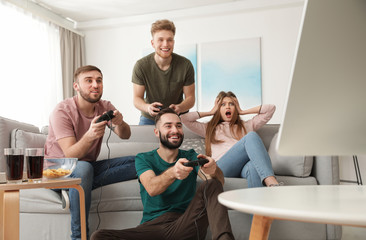 Naklejka premium Emotional friends playing video games at home