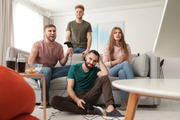 Emotional friends playing video games at home