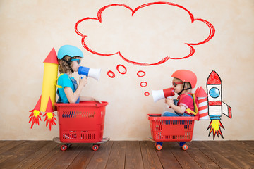 Happy children driving toy car at home