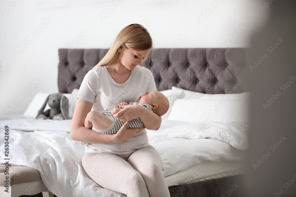 Sticker Young mother with her baby on bed at home