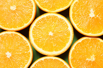 Halves of ripe oranges as background, top view