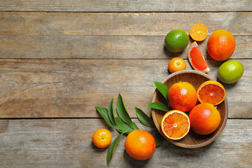 Flat lay composition with different citrus fruits and space for text on wooden background