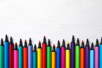 Flat lay composition with colorful markers and space for text on white wooden background. Rainbow palette