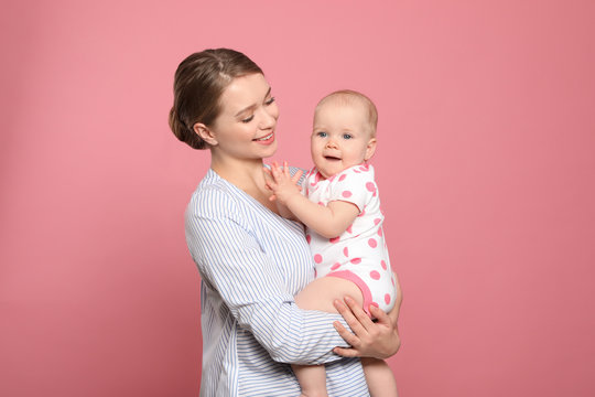 Portrait Of Happy Mother With Her Baby On Color Background