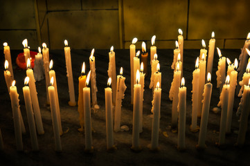 Kerzen; Gelbe brennende Wachskerzen strahlend.