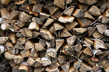 Background of dry chopped firewood logs in a pile