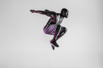 Fototapeta na wymiar Young african-american bodybuilder training over grey background
