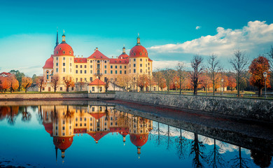 Wonderful Sunny Landscape. Famouse Moritzburg Castle near Dresden lit by the setting sun in the autumn. Saxony, Germany, Europe. Creative image. Awesome nature landscape.