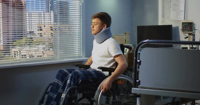 Teenager patient sitting in wheelchair in hospital