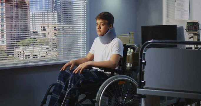 Teenager patient sitting in wheelchair in hospital