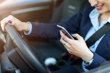 Woman using smartphone while driving a car