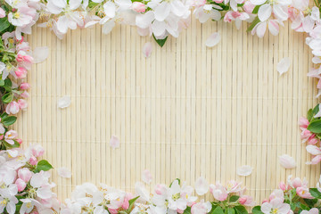 Frame of spring flowers of sakura on bamboo background. Beautiful cherry blossom sakura in springtime