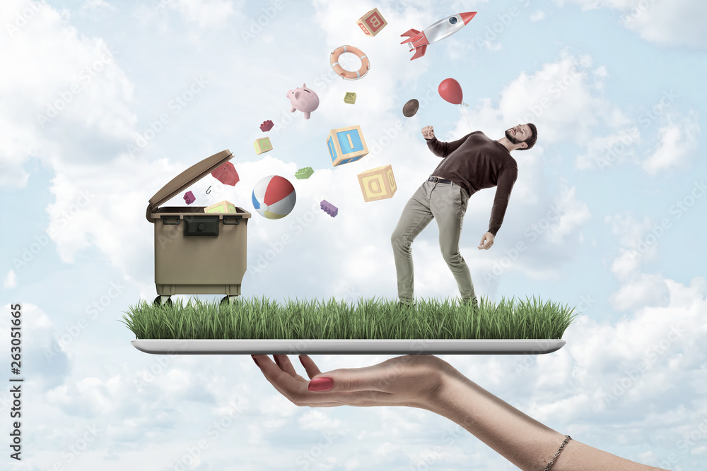 Poster female hand holding a grass model with a man in casual clothes and trash can with random objects fal