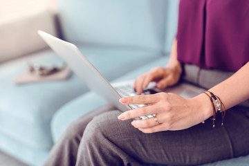 Close-up picture of a female holding a grey laptop