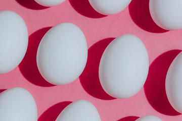 White chicken eggs  with empty space, on a pink background. Abstract image