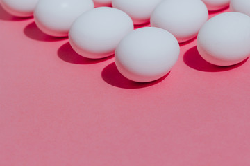 White chicken eggs  with empty space, on a pink background. Abstract image