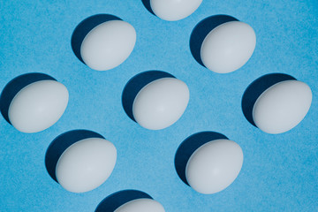 White chicken eggs  with empty space, on a blue background. Abstract image