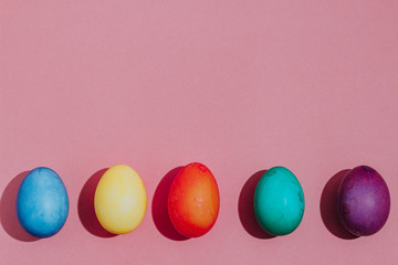 Easter background with Easter eggs. Top view with copy space. multicolored Easter eggs on a pink background