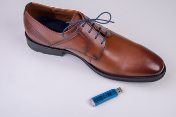 data stick with business shoe against white background