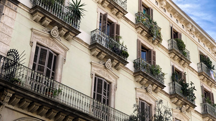 Facade with windows and balconies decorated with plants