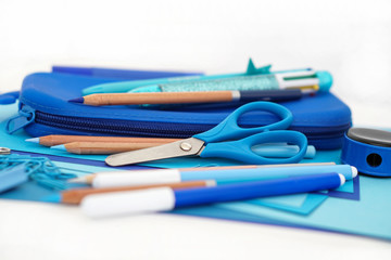 Stationery stack . Back to school. Paper sheets notepad pencils multicolor pen sharpener pencil case scissors . Frame composition with copy space Objects on white background