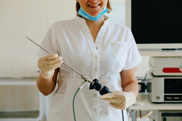 Close up of happy female surgeon in protective wear uniform, medical gloves hysteroscope for...