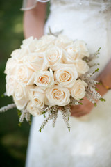 Bride holding bouquet of white roses