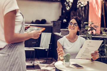 Joyful dark haired woman making an order